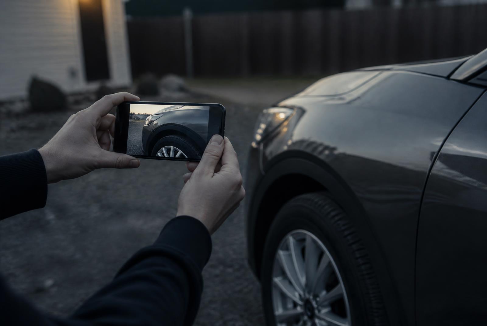 A seller photographing their vehicle with a phone during guided capture